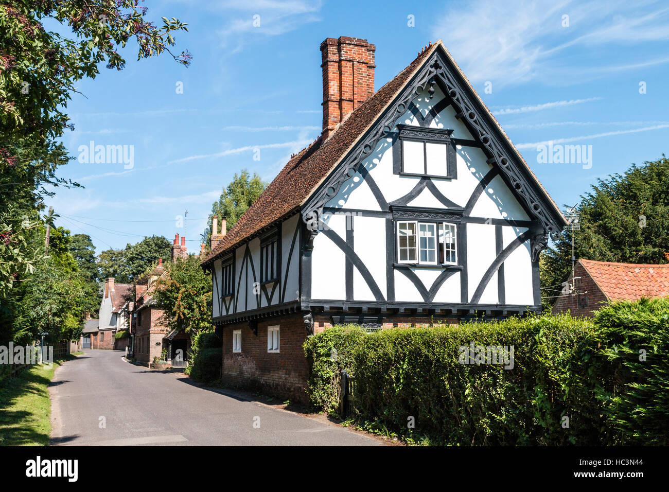 Patrixbourne village in Kent, England. Tudor style farm house, white plaster and black wood frame, on rural road. Bright sunshine. Stock Photo