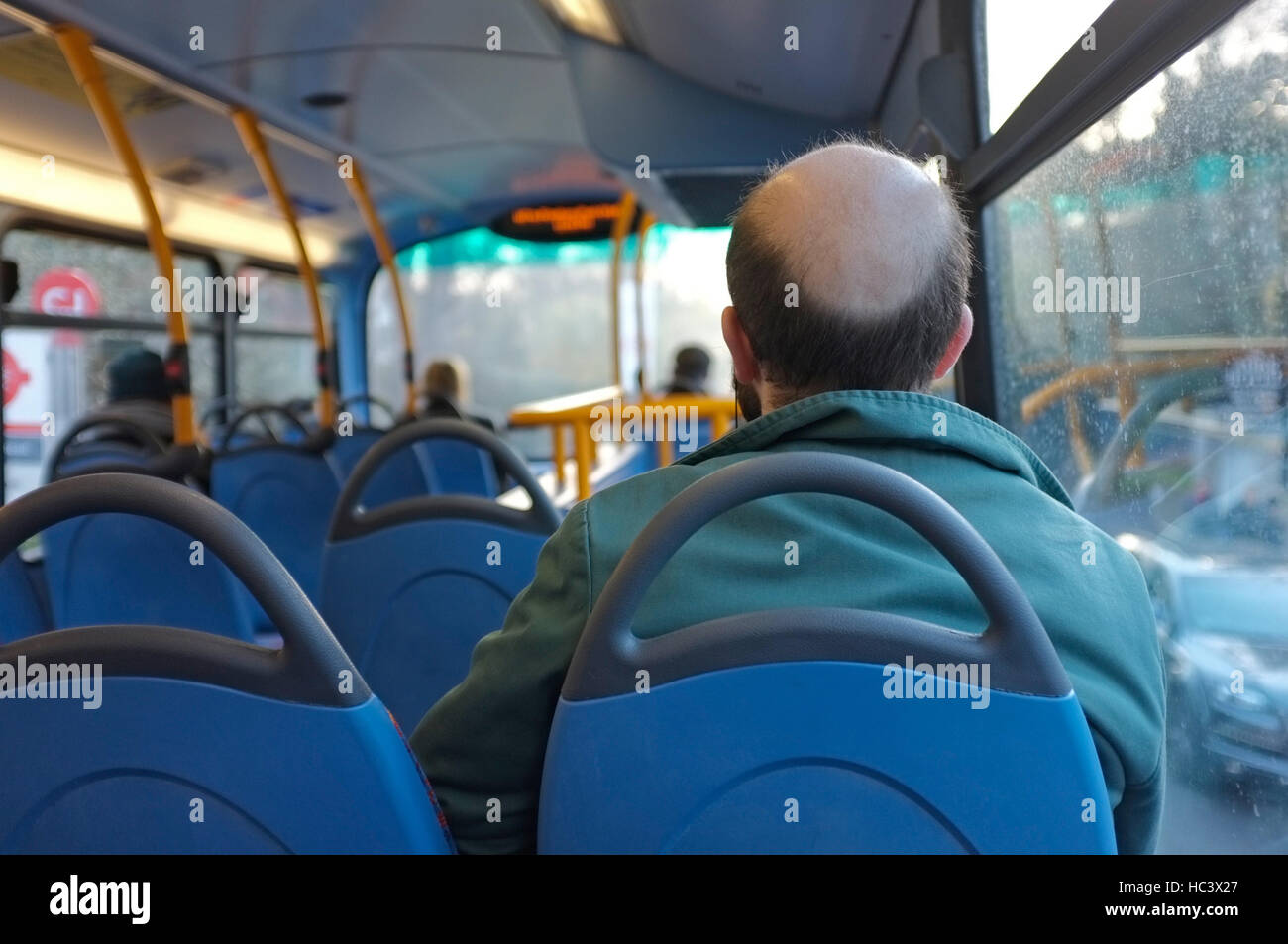 A young man on a London bus with male pattern baldness. Stock Photo