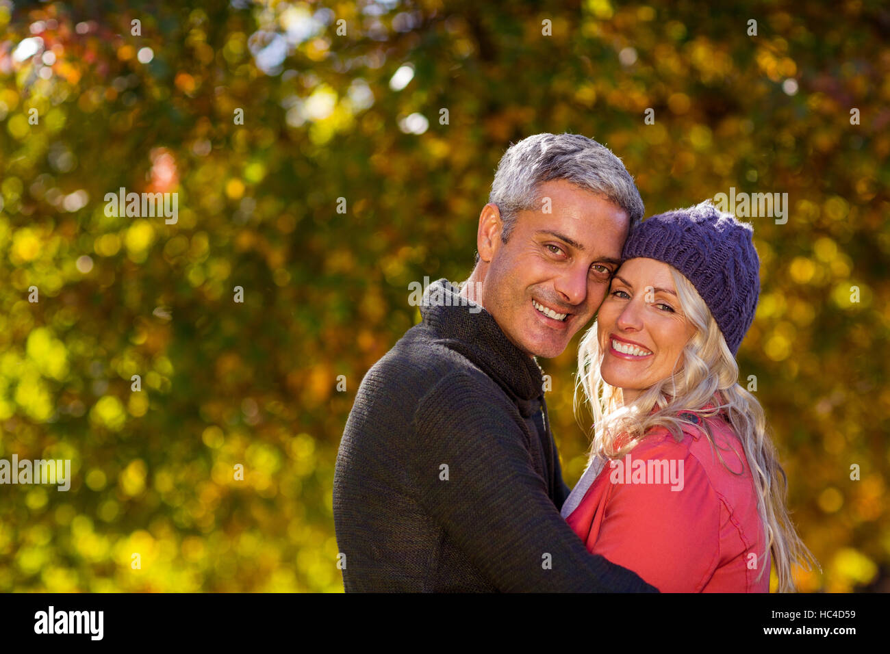 Portrait of couple hugging at park Stock Photo - Alamy