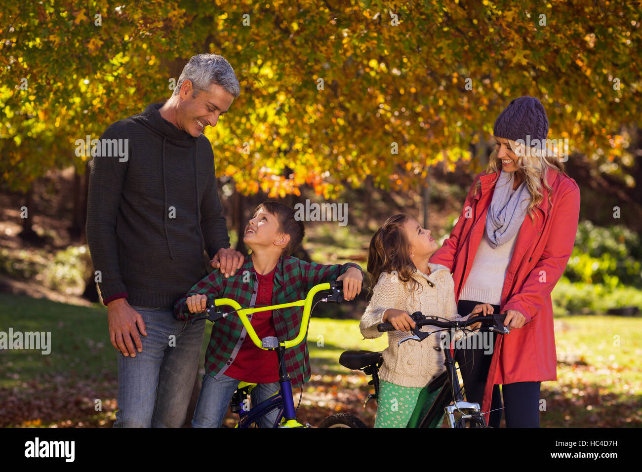 Happy children riding bicycles with parents Stock Photo