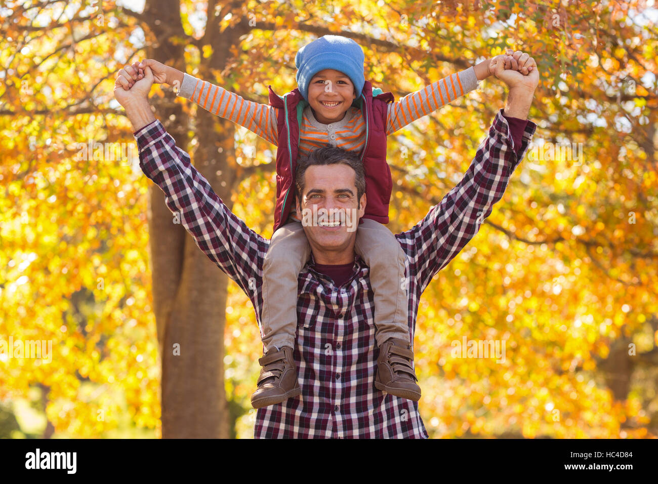 Happy father carrying son on shoulder at park Stock Photo