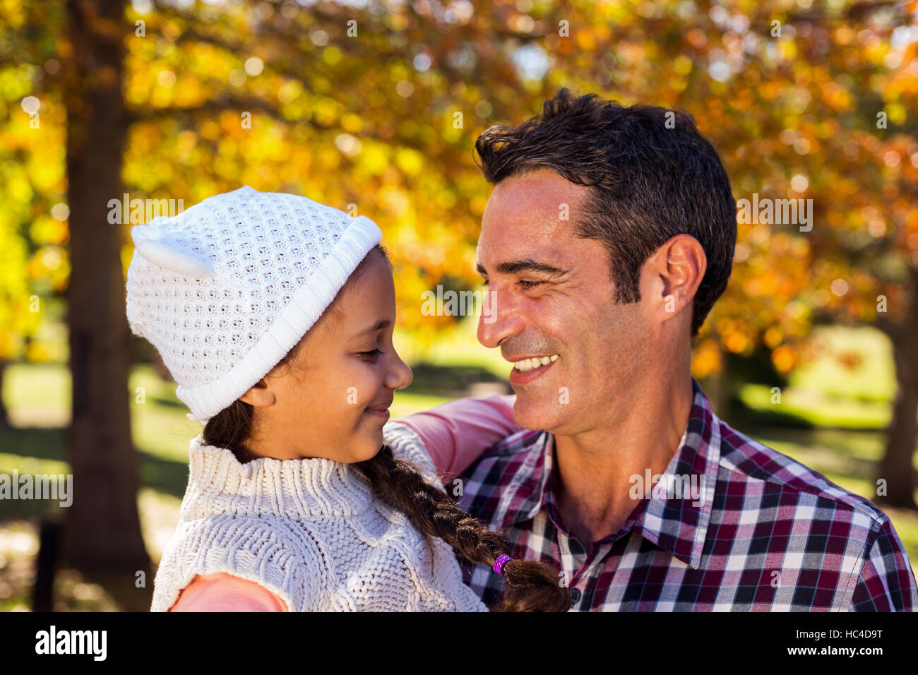 Smiling father carrying daughter at park Stock Photo - Alamy