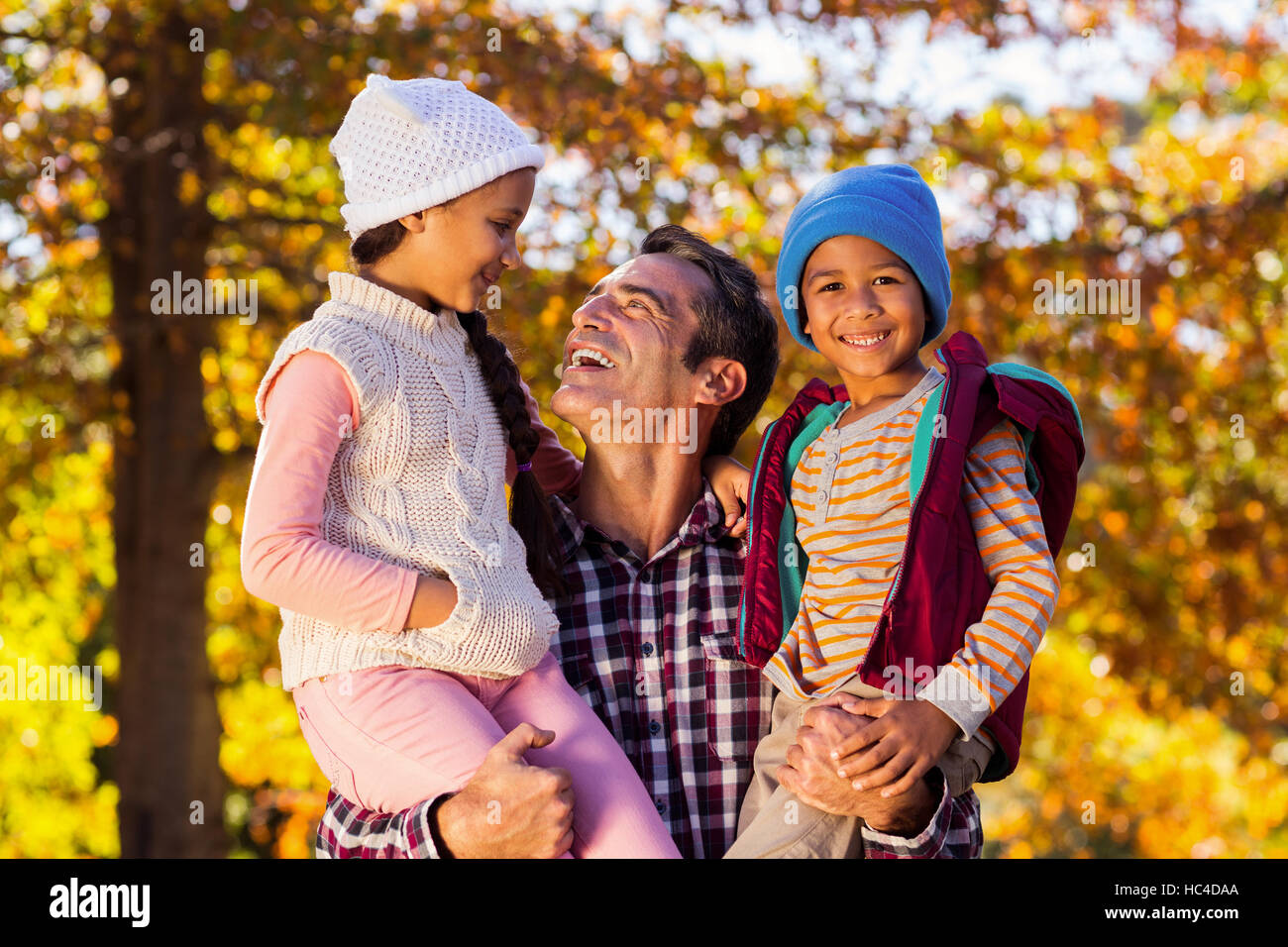 Happy father carrying children at park Stock Photo - Alamy