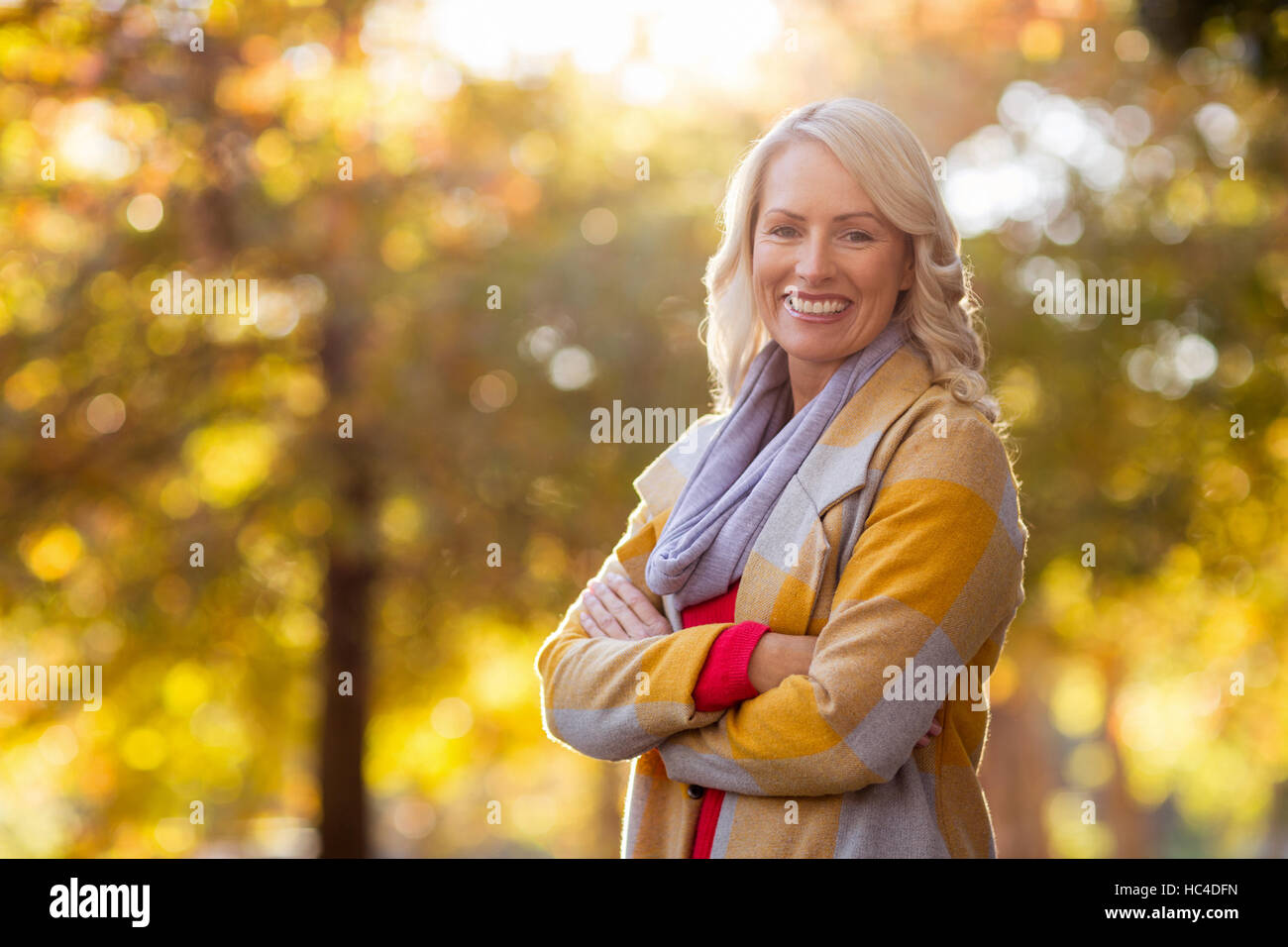 Portrait of young woman standing at park Stock Photo - Alamy