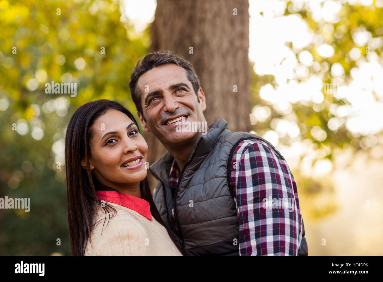 Romantic couple against tree Stock Photo - Alamy