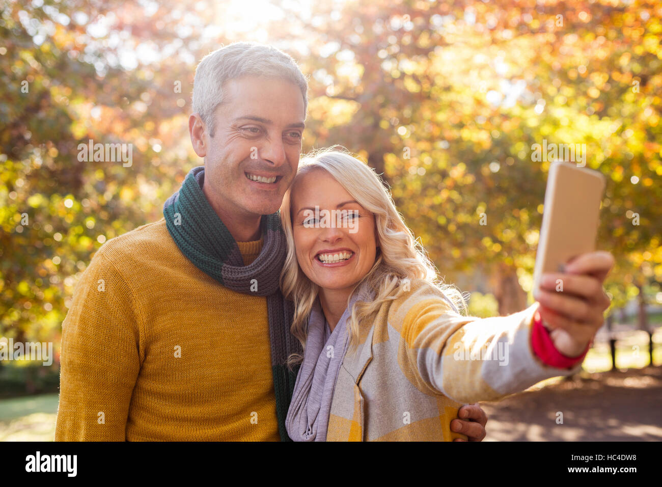 Smiling couple taking selfie at park Stock Photo - Alamy