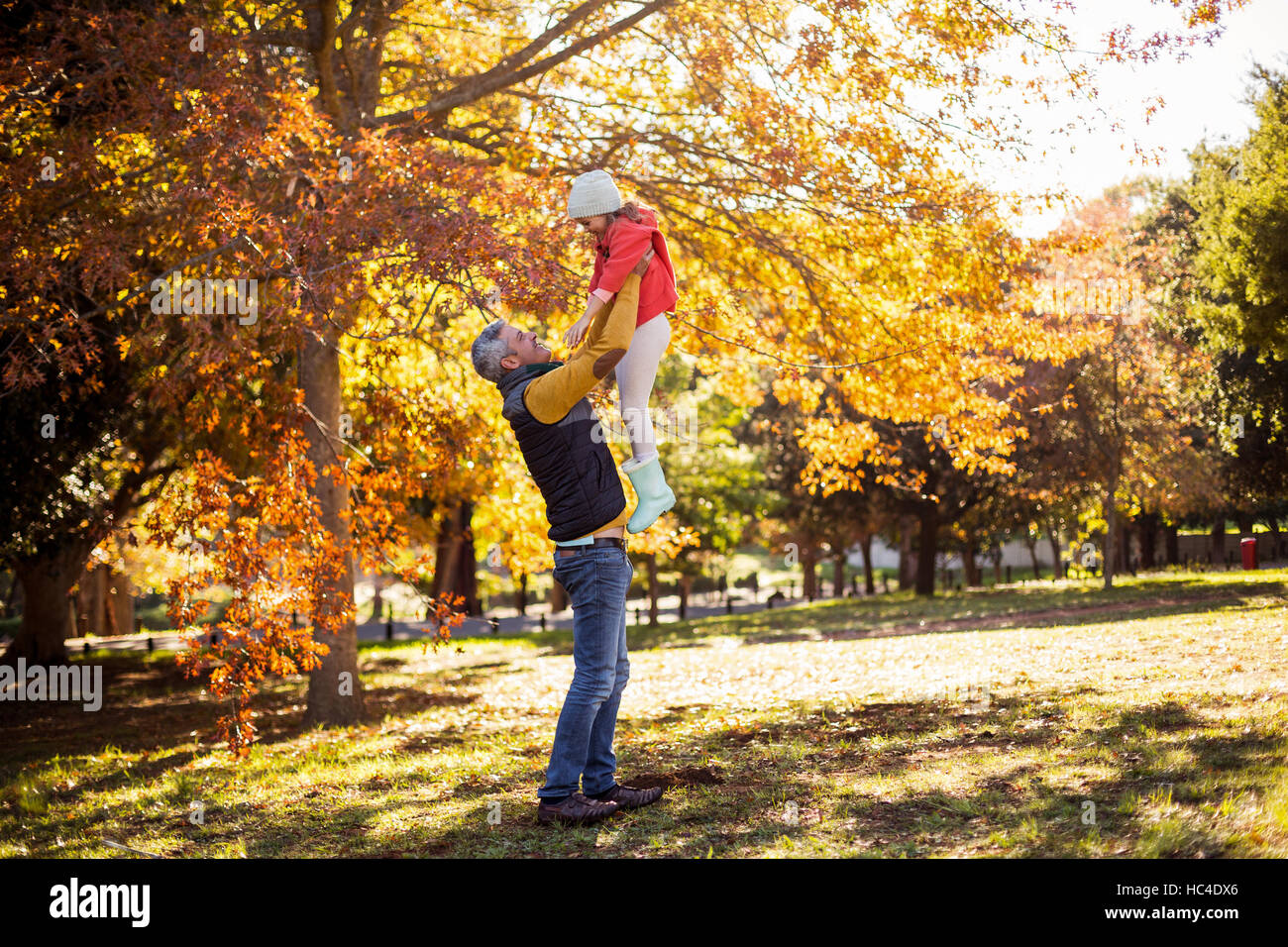 Full length of father holding daughter at park Stock Photo - Alamy