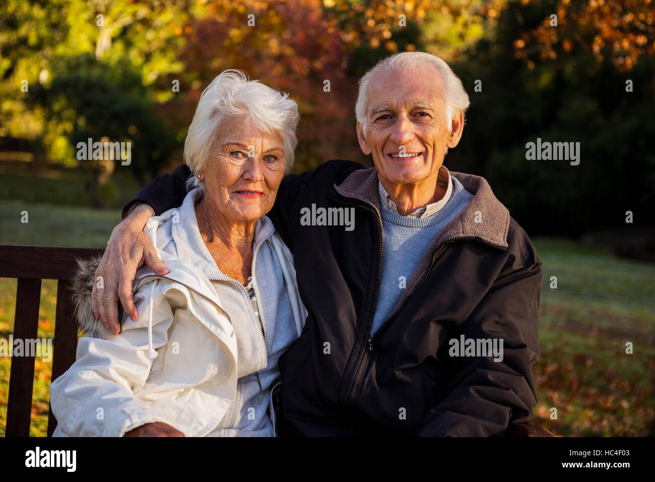 Elderly couple sitting on a bench Stock Photo - Alamy