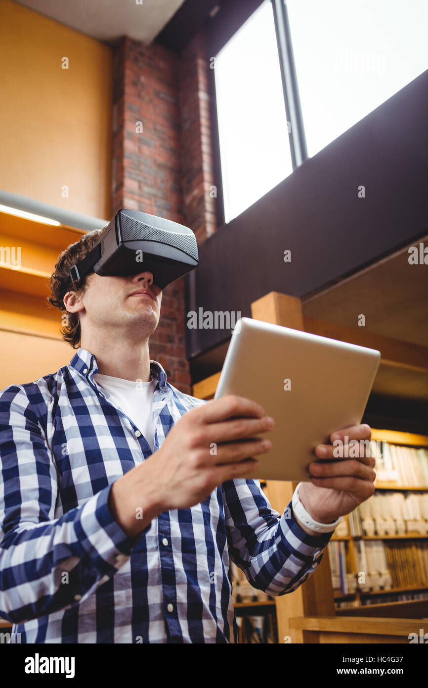Student using digital tablet and virtual reality headset in library Stock Photo