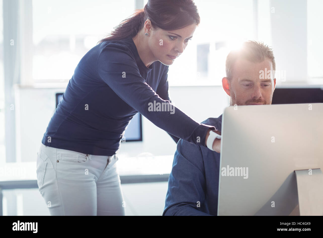 Teacher assisting mature student in computer room Stock Photo - Alamy