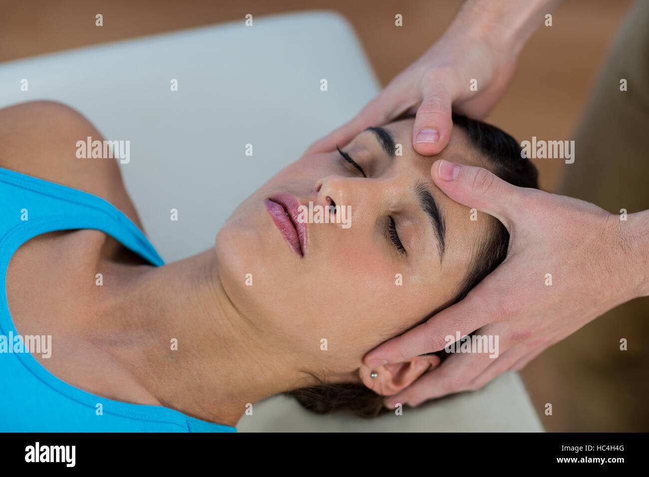 Male physiotherapist giving head massage to female patient Stock Photo