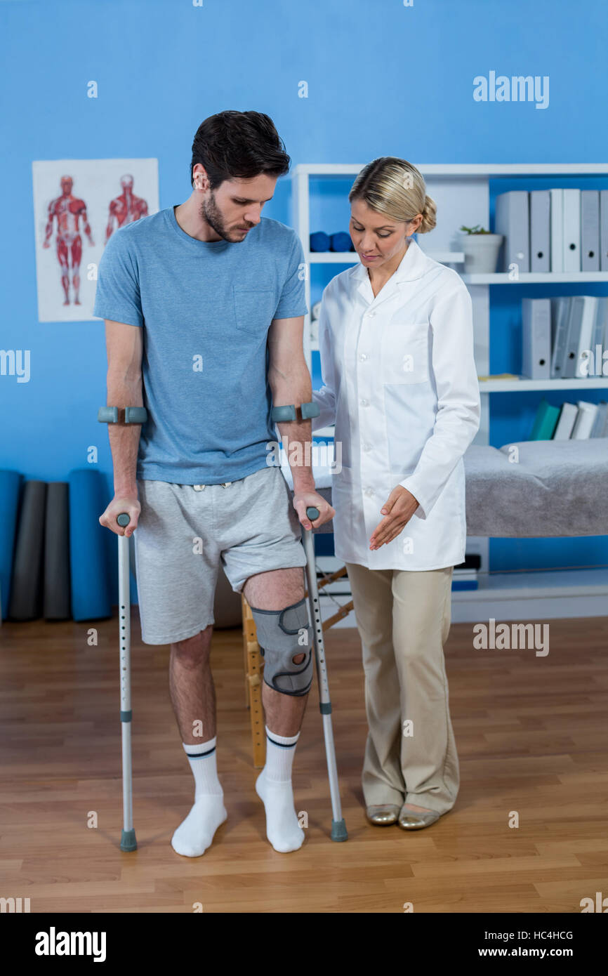 Physiotherapist helping patient to walk with crutches Stock Photo Alamy