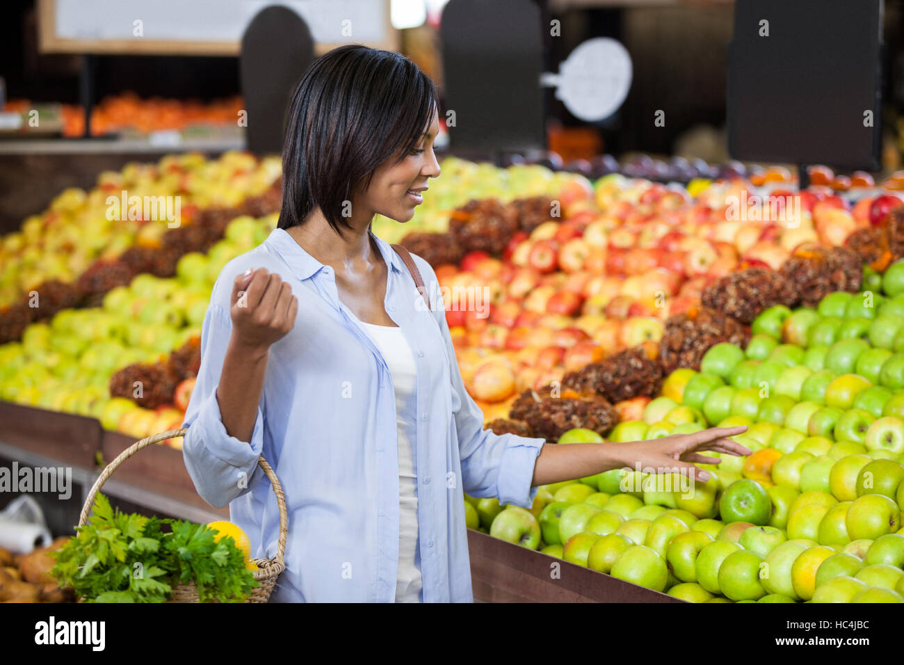 Smiling woman buying fruits in organic section Stock Photo
