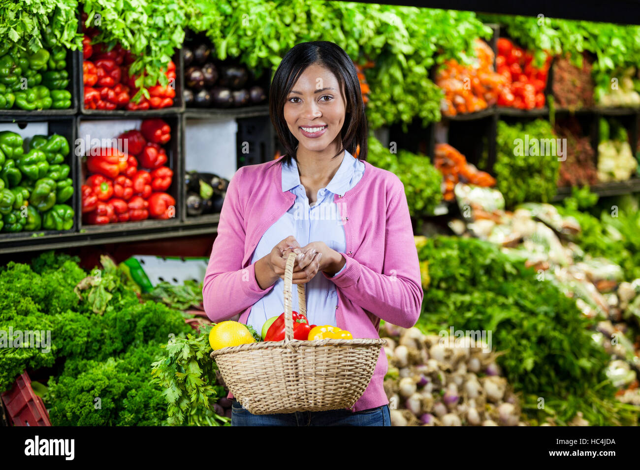 Smiling woman holding fruits and vegetables in basket Stock Photo - Alamy