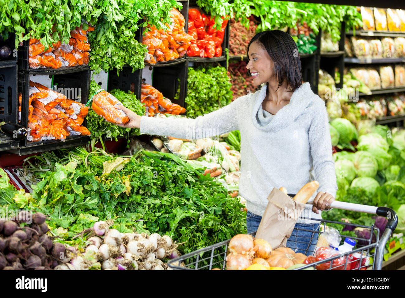 Woman buying carrot in organic section Stock Photo