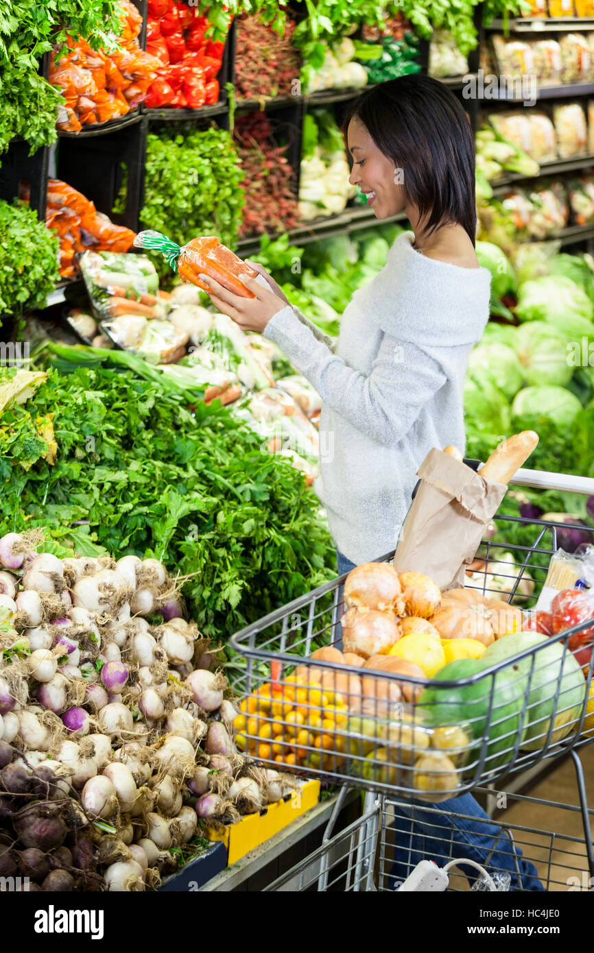 Woman buying carrot in organic section Stock Photo