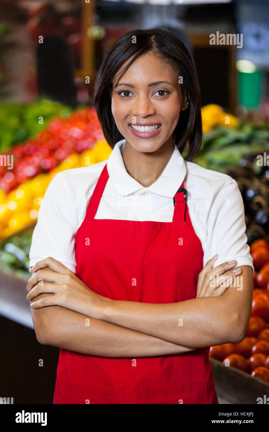 Smiling female staff standing with arms crossed in organic section Stock Photo
