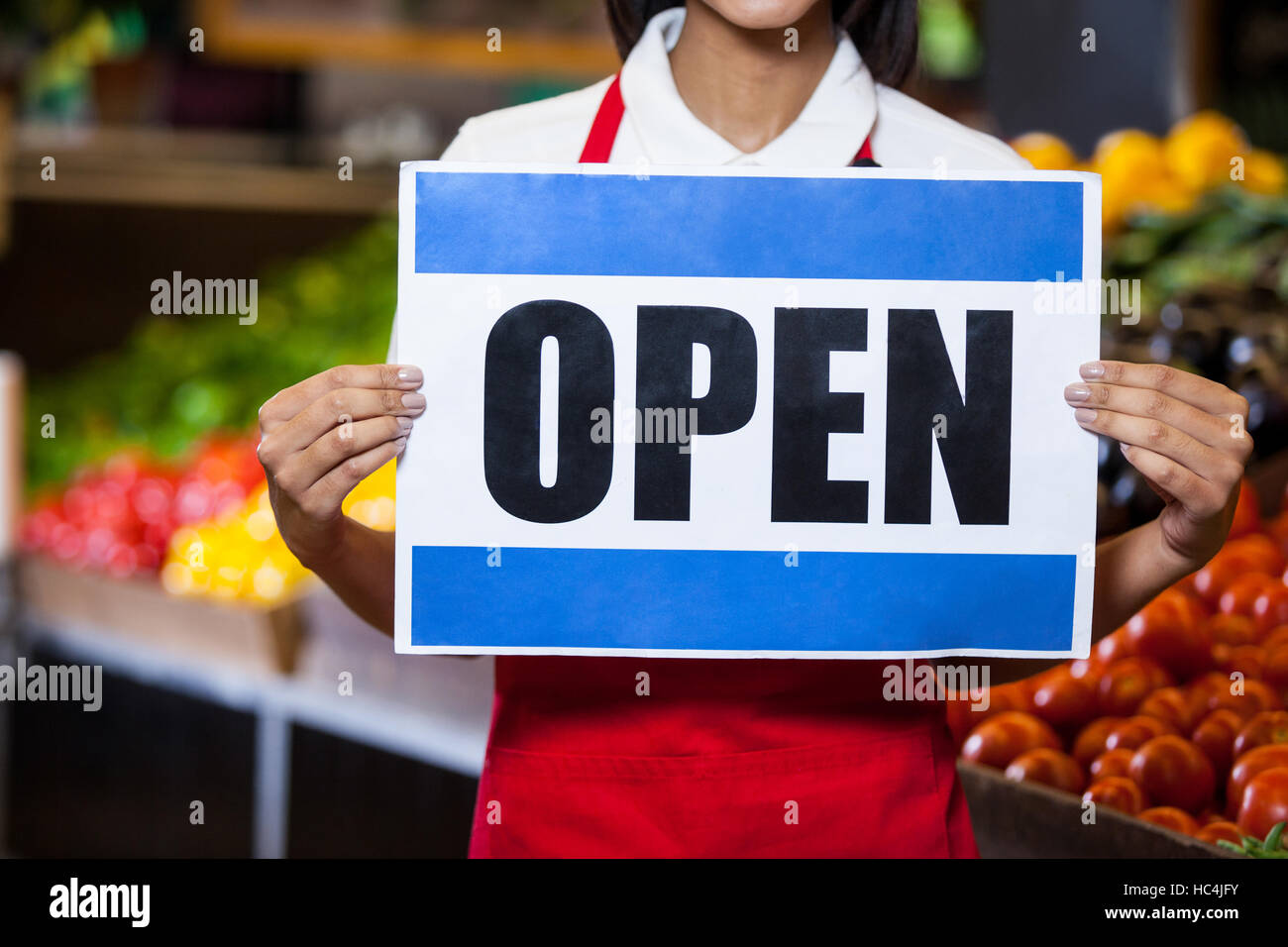 Female staff holding open signboard Stock Photo