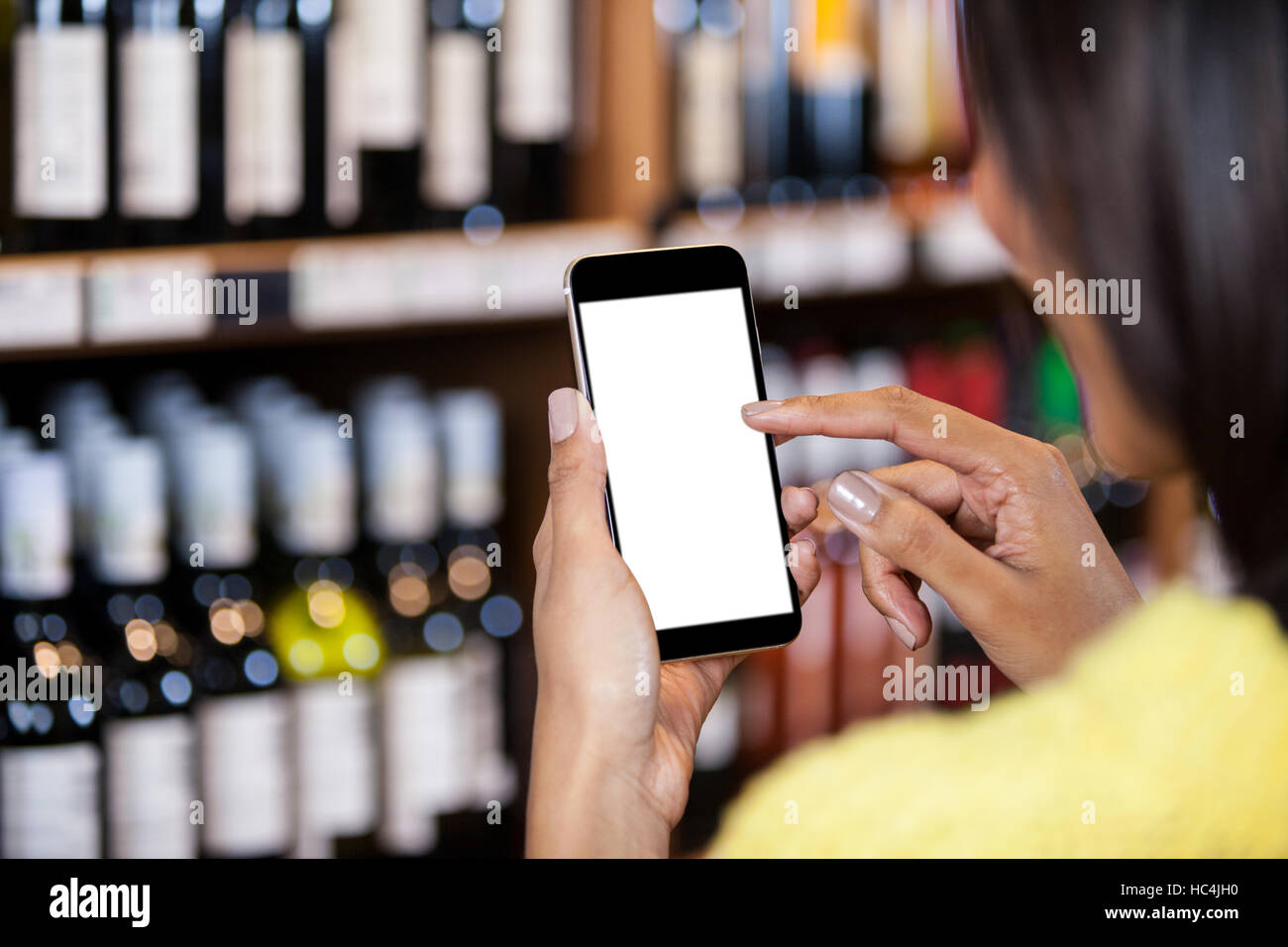Woman using mobile phone in grocery section Stock Photo