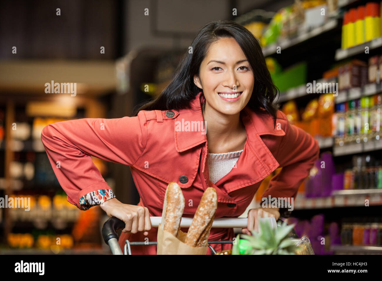 Woman holding shopping cart in organic section Stock Photo
