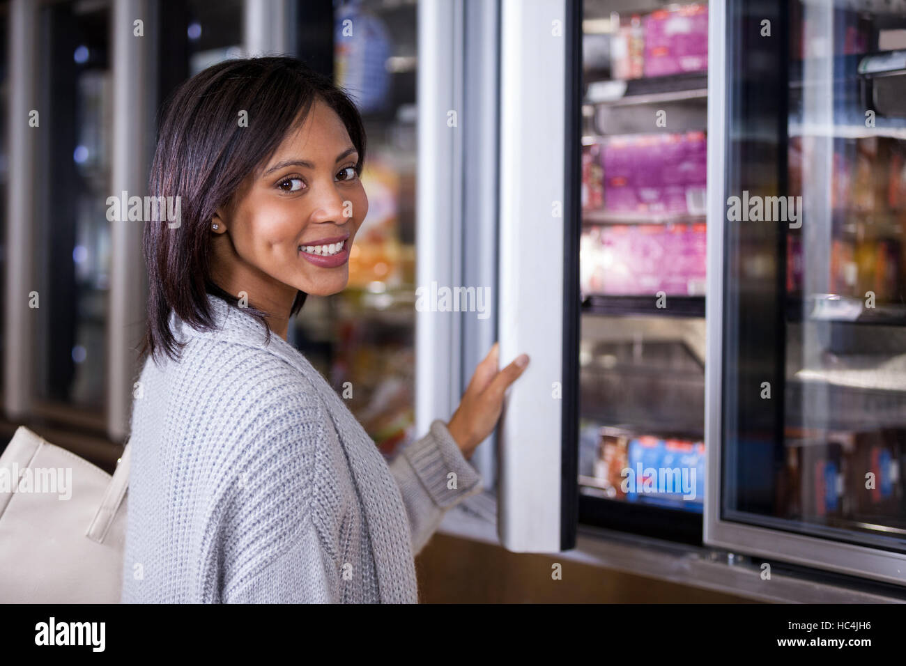 Woman standing near refrigerator Stock Photo
