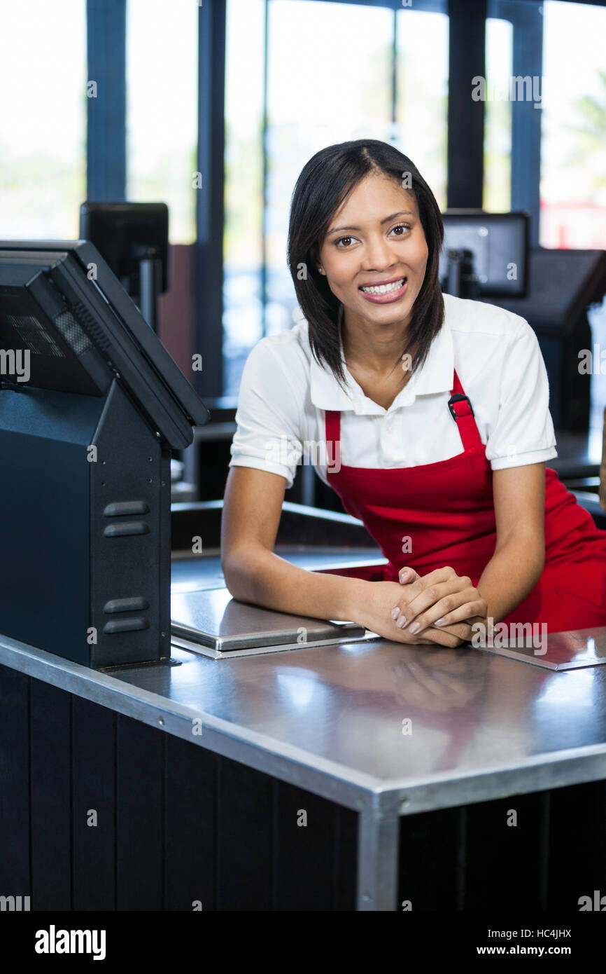 Female staff sitting at cash counter Stock Photo