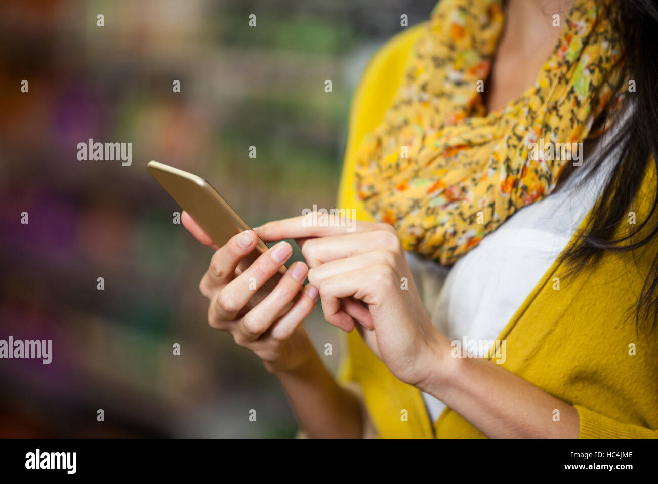 Woman using mobile phone in grocery section Stock Photo