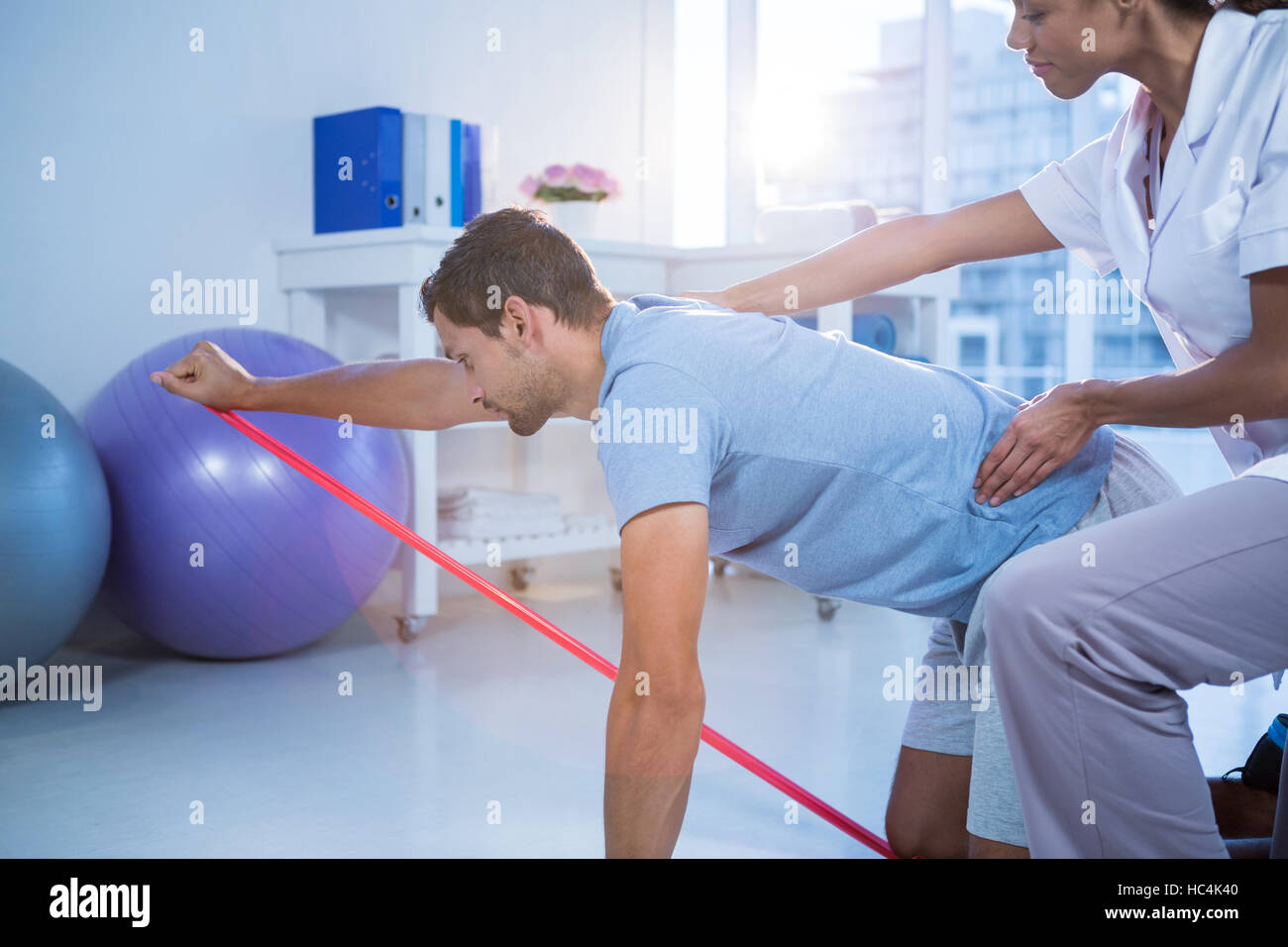 Female physiotherapist assisting a male patient while exercising Stock Photo