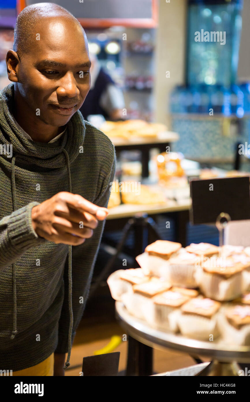 Smiling man purchasing sweet food Stock Photo