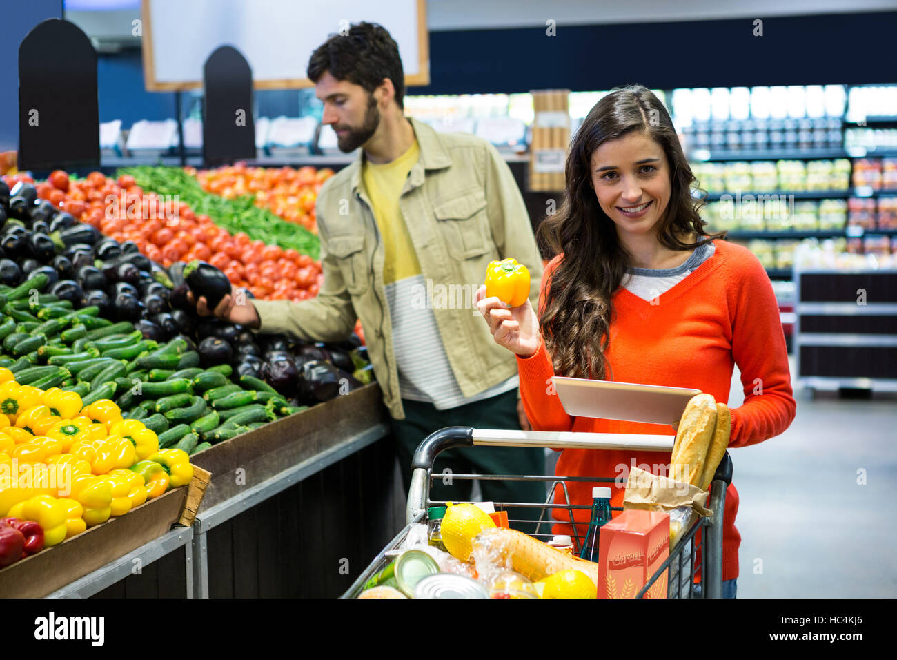 Happy couple selecting vegetables in organic section Stock Photo