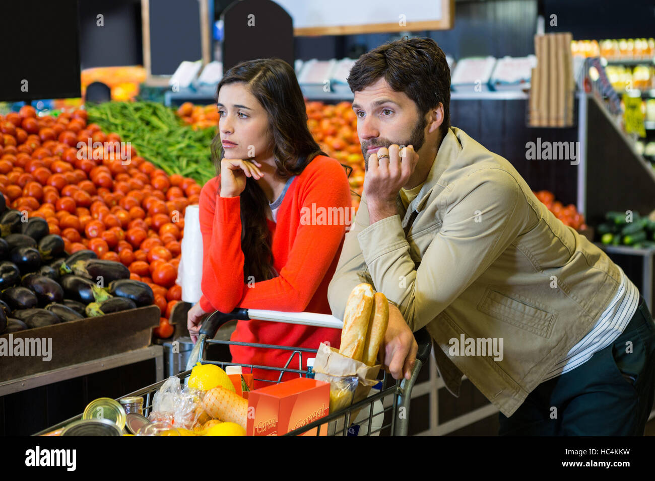 Bored couple with shopping trolley in organic section Stock Photo