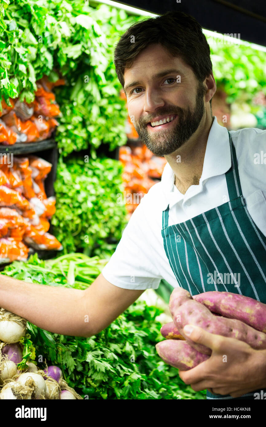 Male staff arranging vegetables in organic section Stock Photo