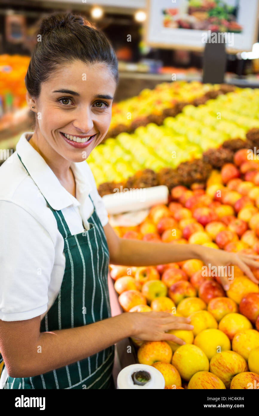 Female staff arranging fruits in organic section of supermarket Stock Photo