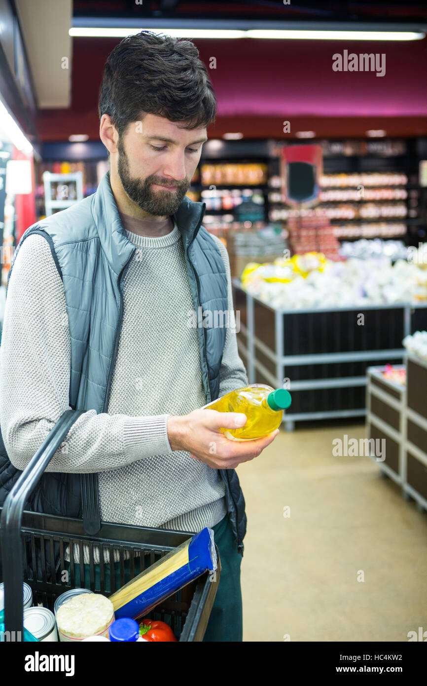Man holding oil bottle shopping basket Stock Photo