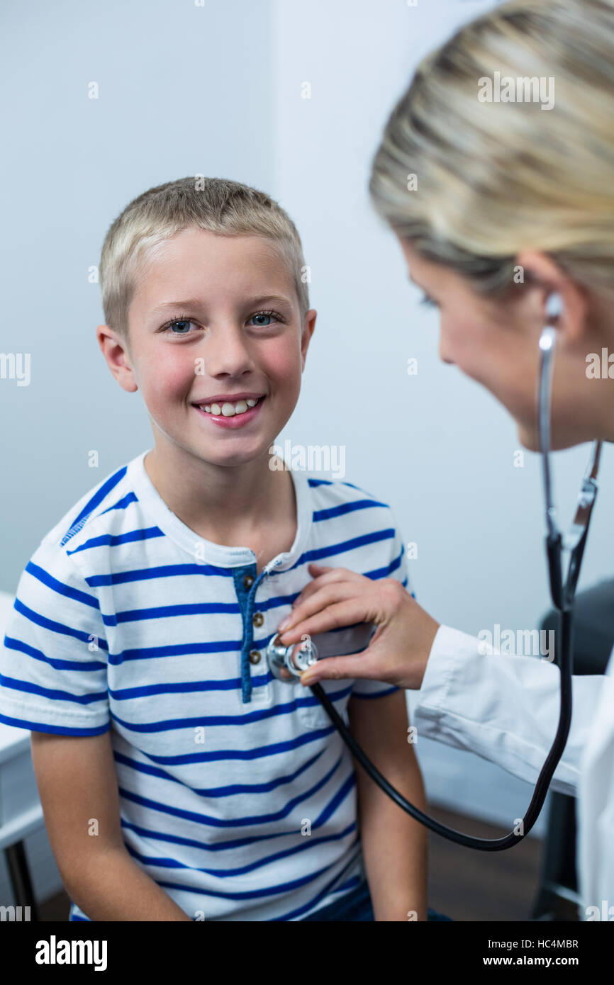 Female doctor examining young patient with a stethoscope Stock Photo ...