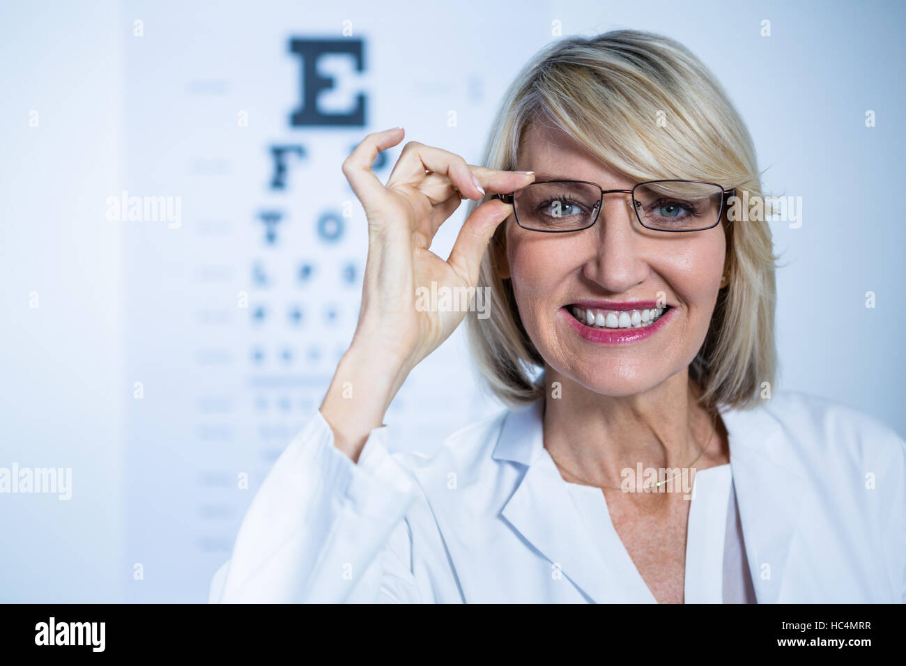 Smiling female optometrist wearing spectacles Stock Photo