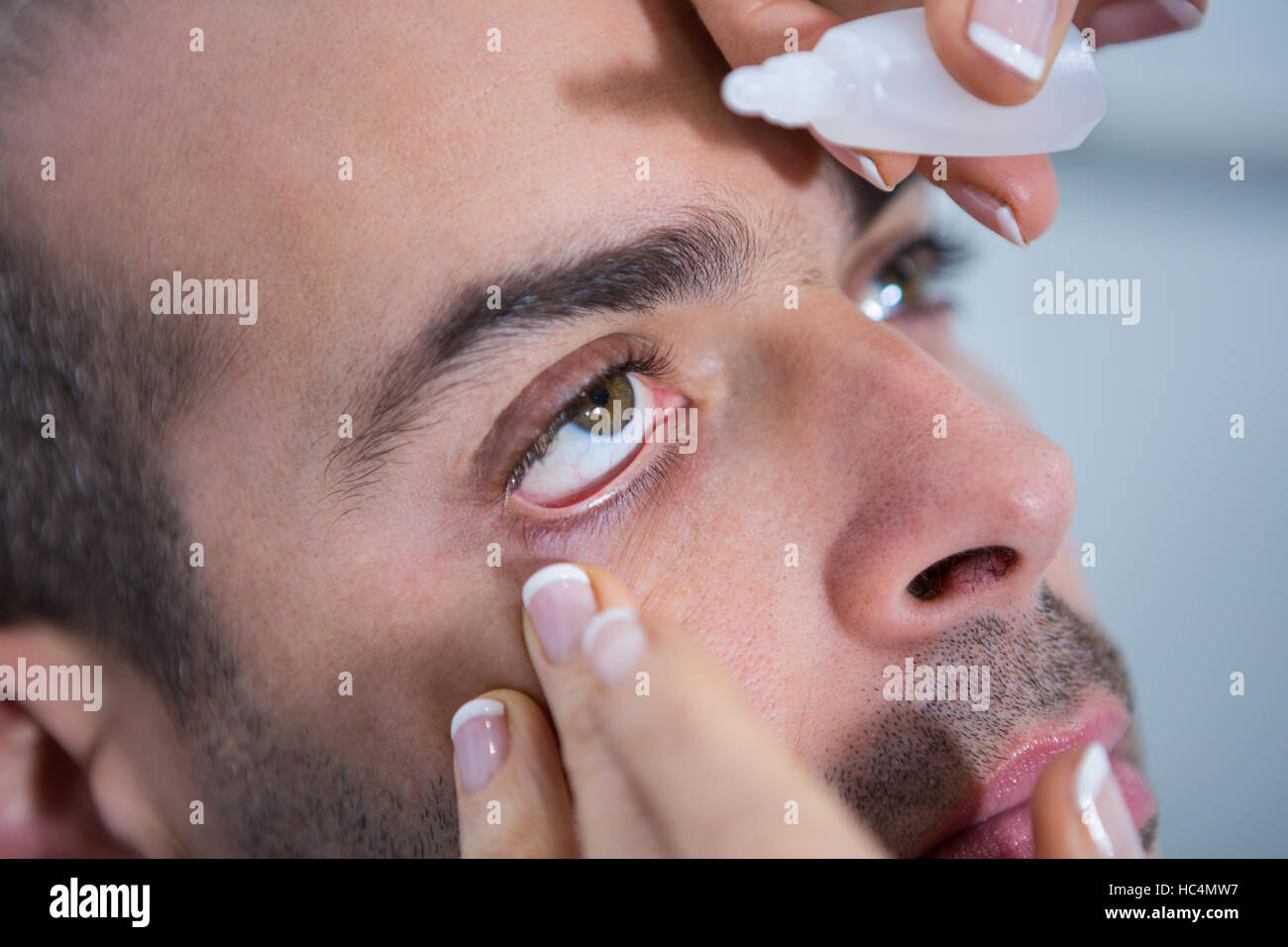 Optometrist putting drops into patients eyes Stock Photo Alamy