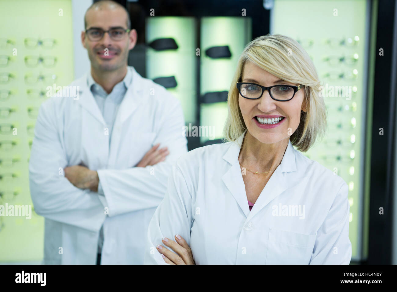 Smiling optometrists standing with arms crossed Stock Photo