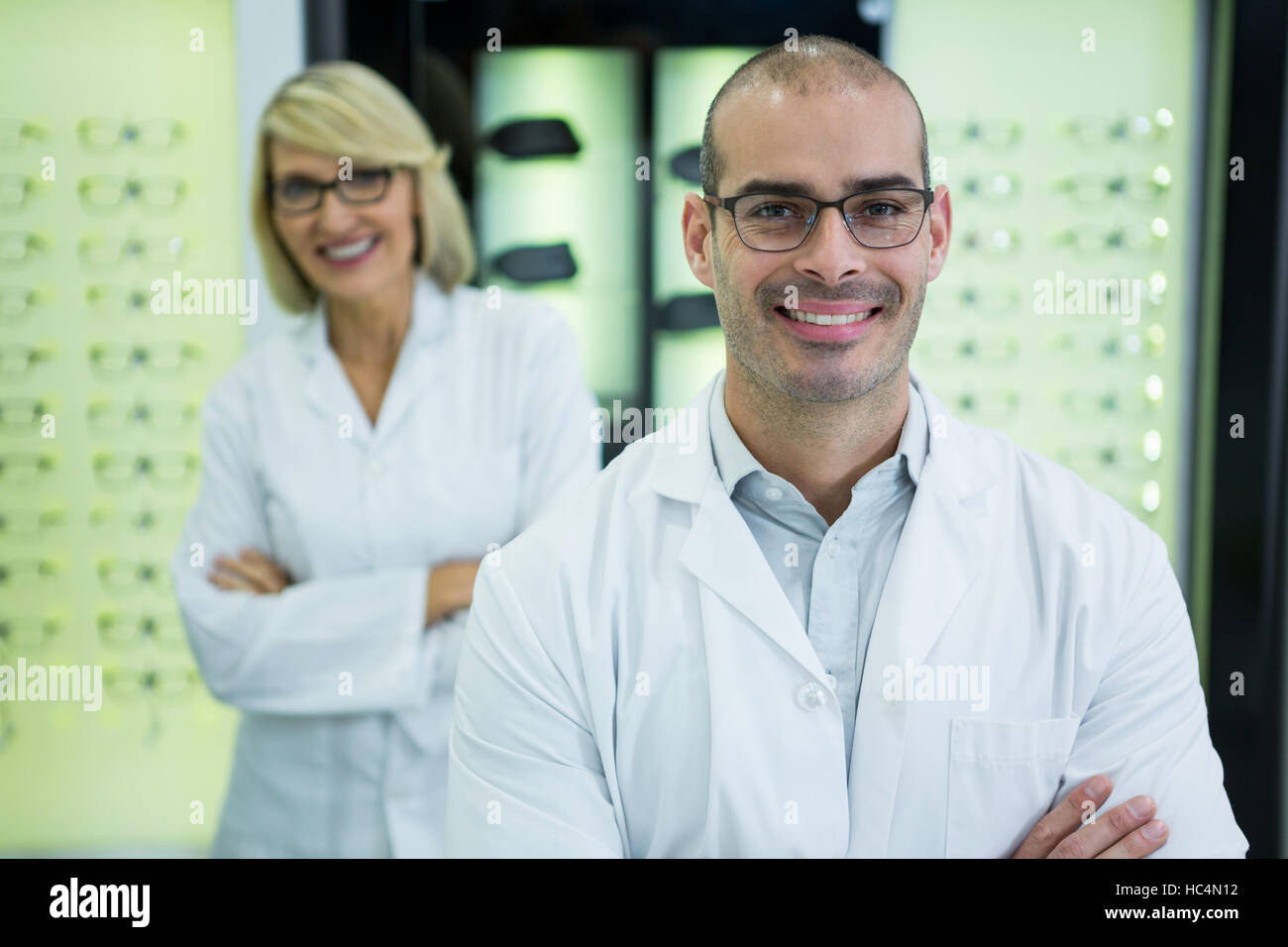 Smiling optometrists standing with arms crossed Stock Photo - Alamy