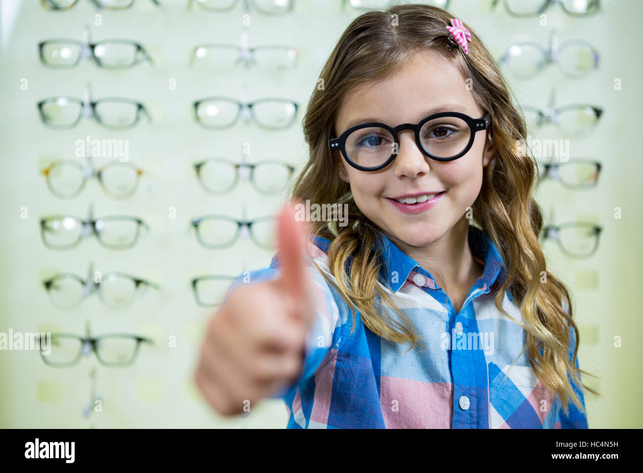 Portrait of girl showing thumbs up Stock Photo - Alamy
