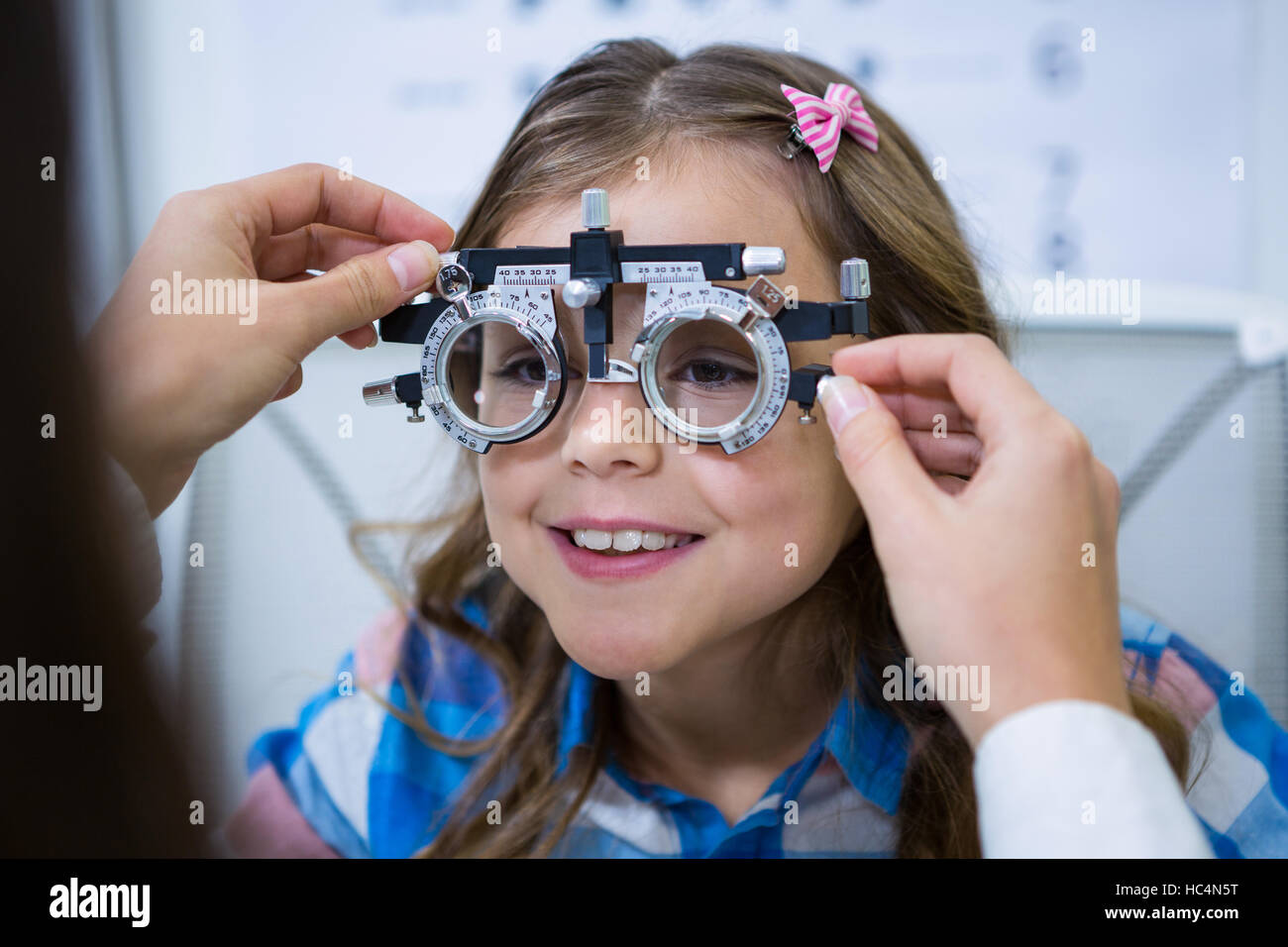 Female optometrist examining young patient with trial frame Stock Photo