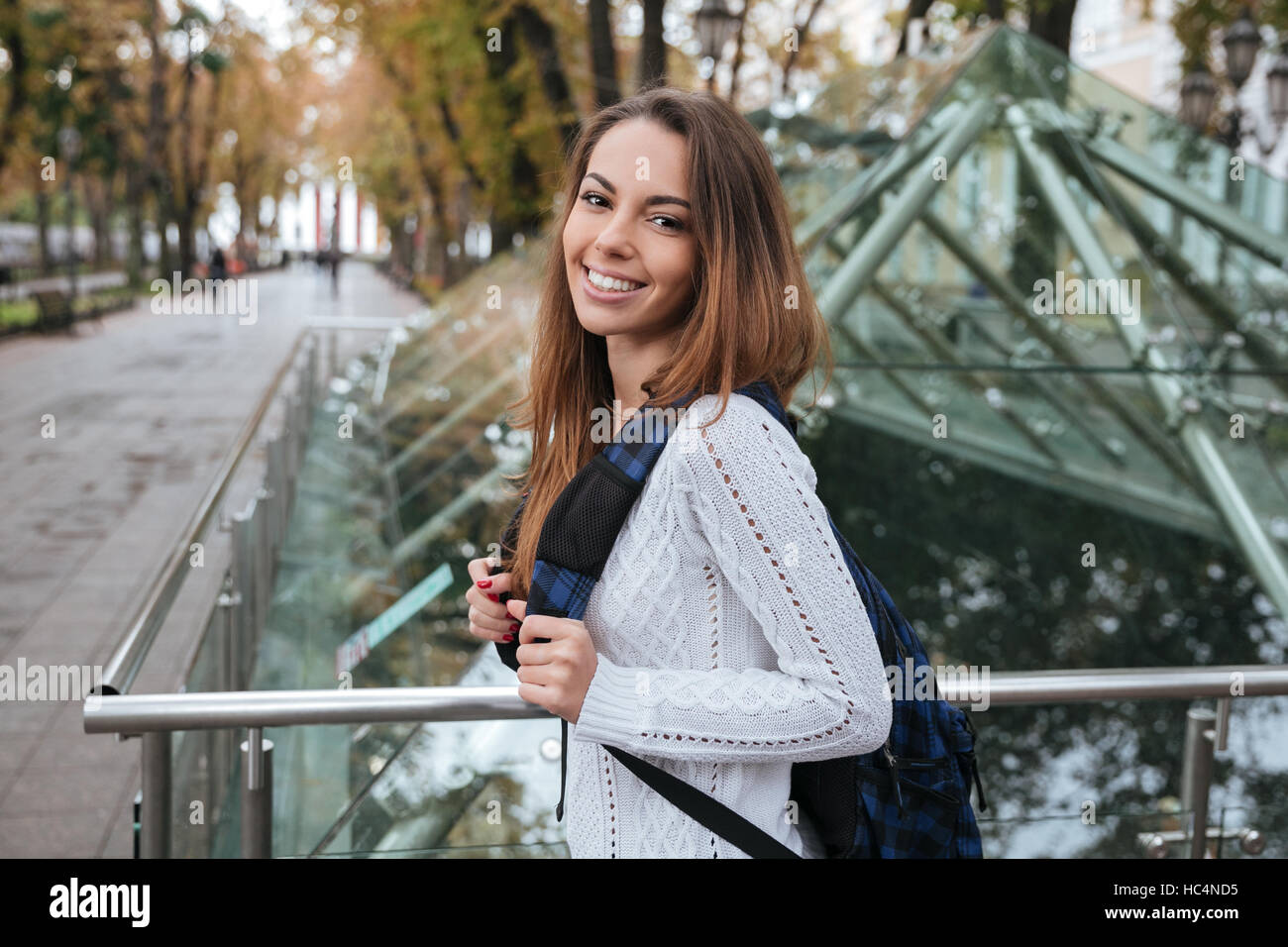 Portrait of cheerful lovely young woman with backpack in park Stock ...