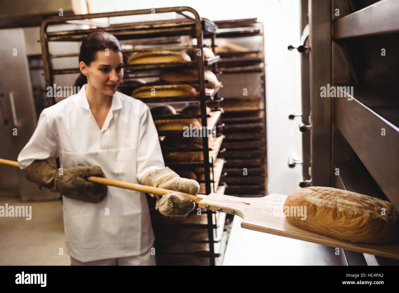 https://c8.alamy.com/comp/HC4PA2/female-baker-baking-fresh-bread-HC4PA2.jpg