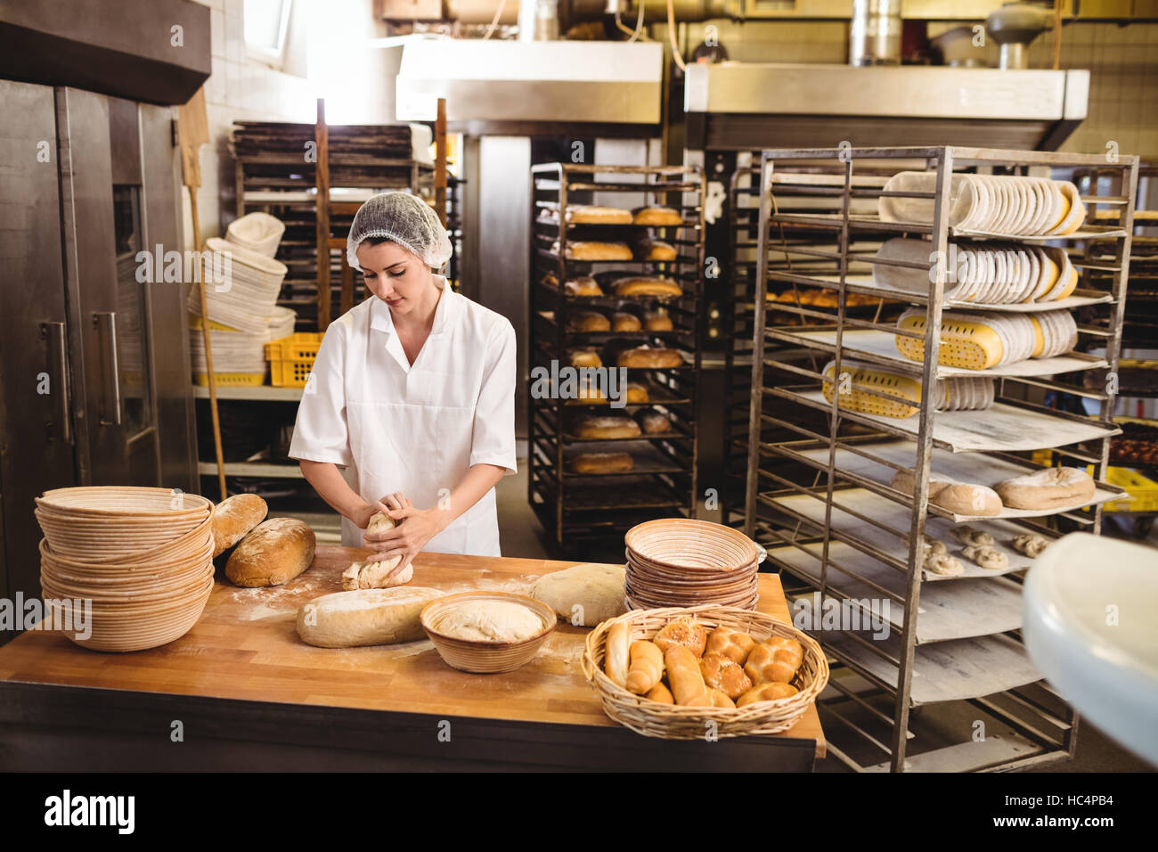Female baker kneading a dough Stock Photo Alamy