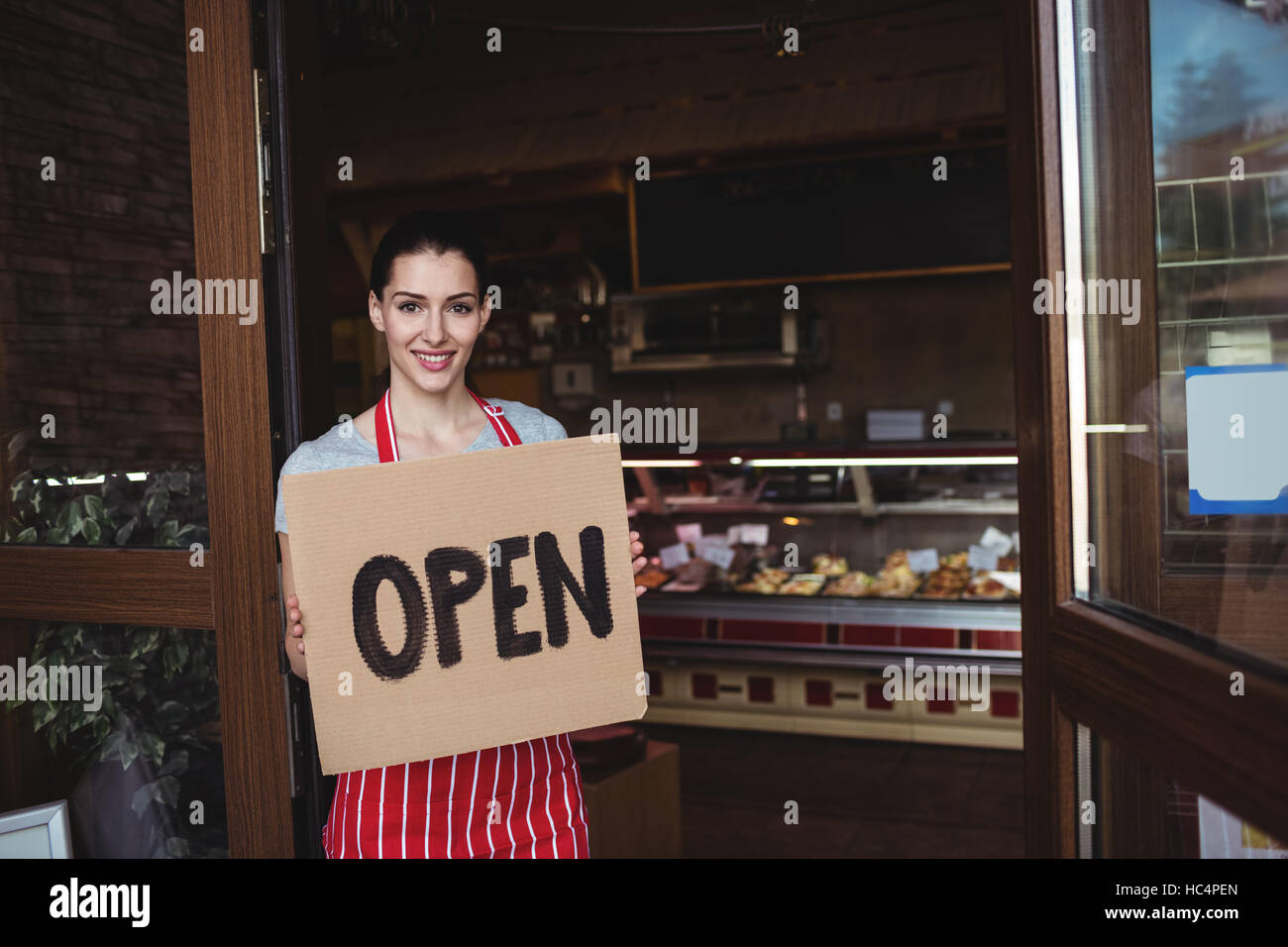 Female baker holding open signboard Stock Photo Alamy