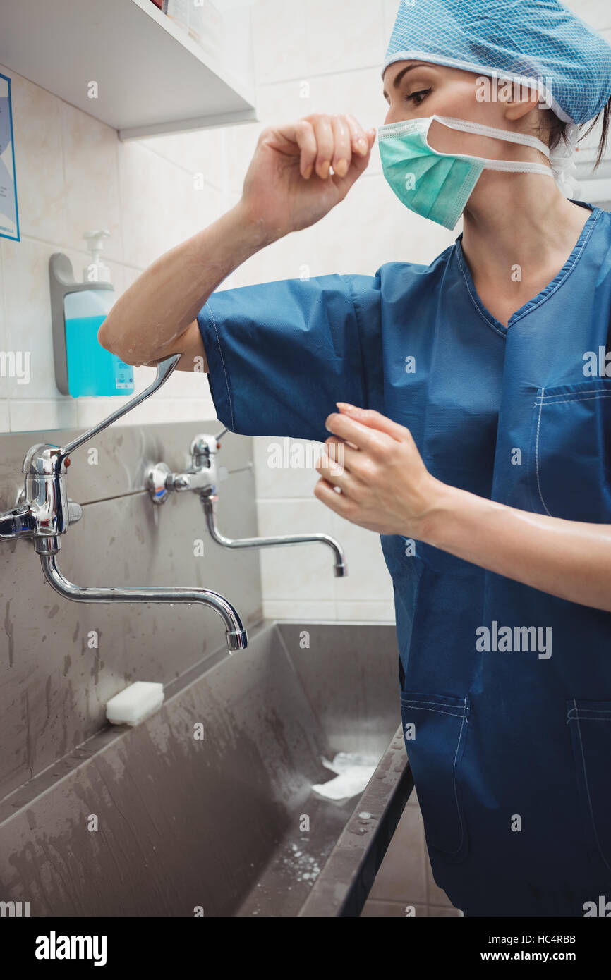 Female surgeon washing hands prior to operation using correct technique