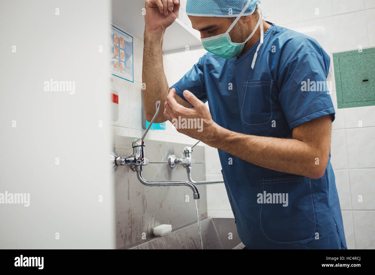 Male surgeon washing hands prior to operation using correct technique