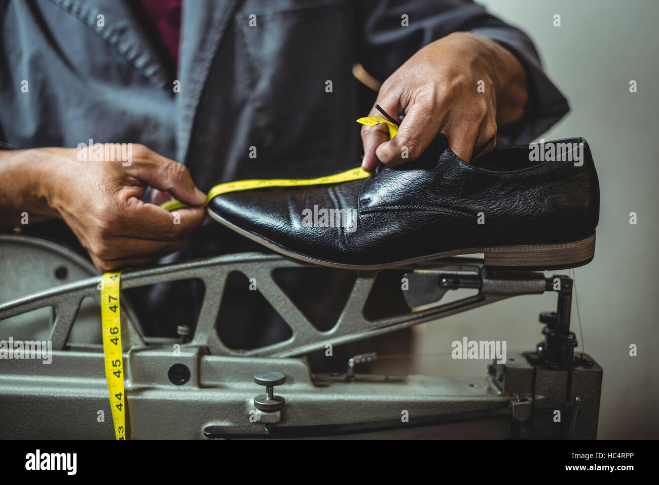 Shoemaker measuring a shoe with measure tape Stock Photo Alamy