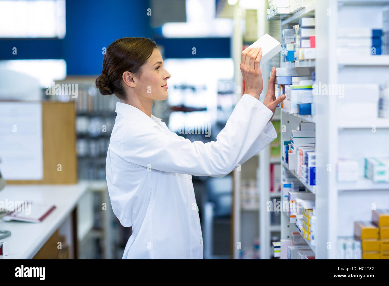 Pharmacist checking medicine in shelf Stock Photo Alamy
