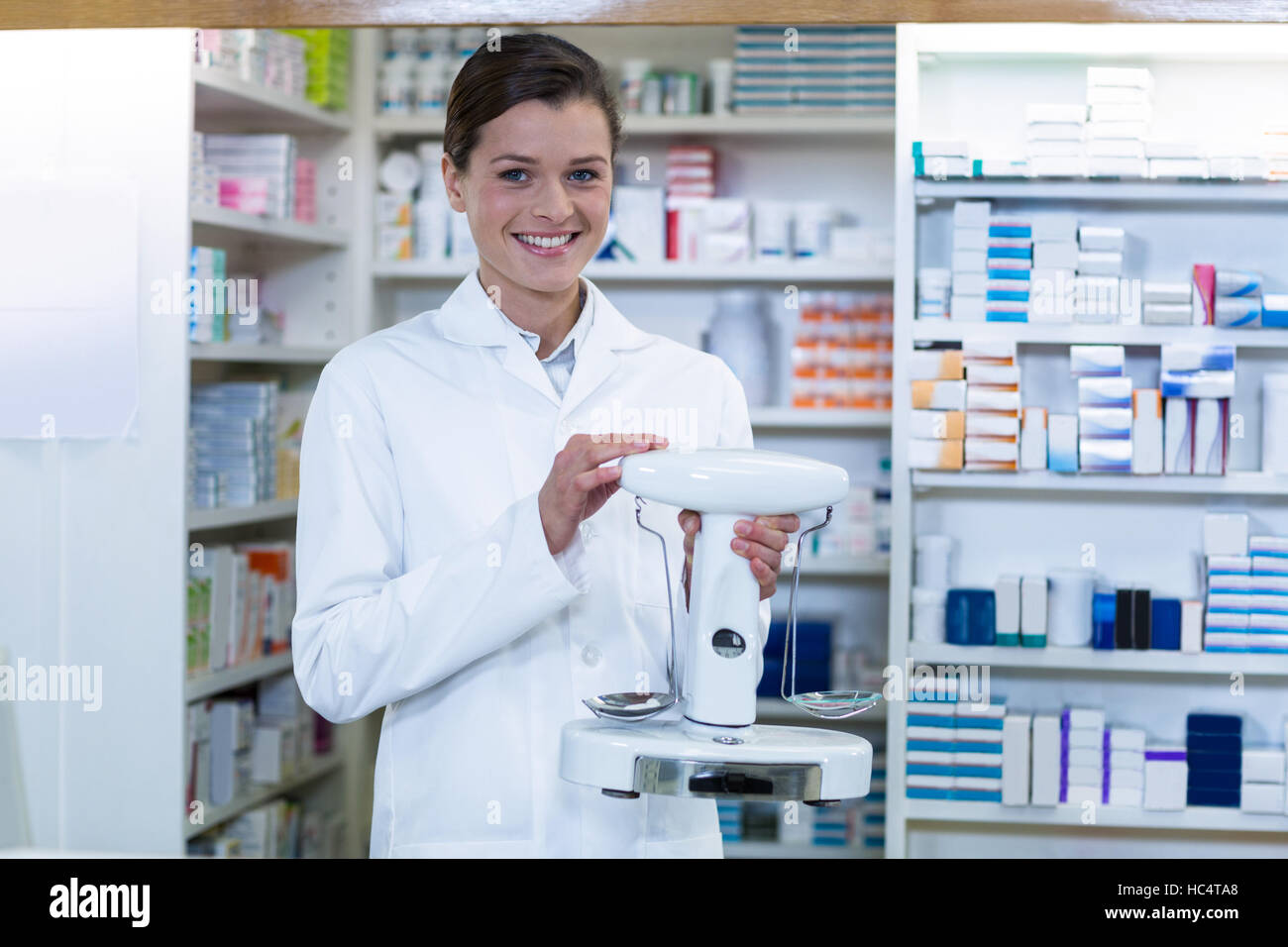 Pharmacist measuring tablets with pharmacy scale in pharmacy Stock